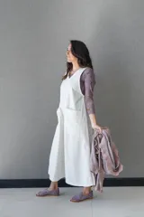 Vestido blanco de gabardina de algodón, corte evasé, sin mangas, con cuello redondo y bolsillo delantero.