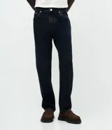 Pantalón de jean masculino con corte recto, confeccionado en algodón. Presenta un diseño clásico con cintura con presillas, cierre frontal con botón y cremallera, y bolsillos funcionales. Incluye sutiles detalles con efecto desgastado.