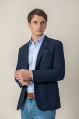 Saco sport color beige de jersey, corte slim fit, con cierre de dos botones, solapa de muesca, bolsillo de parche en el pecho y bolsillos delanteros con solapa.
