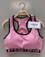 Top deportivo rosa con breteles anchos y contorno negro, con push up removible y banda inferior con la inscripción "THE HONEY".