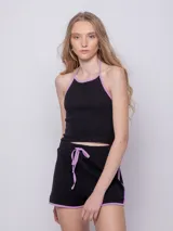 Short negro de tejido de punto con pequeños calados, pretina con cordón ajustable y terminaciones con ribete color lila.