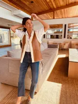 Chaleco plateado reversible con interior de gamulan color crema, con bolsillos delanteros.