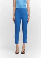 Pantalón skinny crop de tiro alto, con diseño entallado y cierre oculto de botón, gancho y cremallera. Presenta bolsillos de ribete en la parte posterior y un pequeño tajo en el ruedo.
