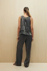 Pantalón negro de corte recto y tela liviana con brillo metalizado.