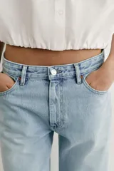 Jeans Z1975 de tiro alto y corte slim, color azul con lavado medio, diseño de cinco bolsillos y bajo sin costuras. Cierre frontal con cremallera y botón metálico.