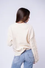Sweater de punto con diseño de trenzas y rombos, color marrón, de cuello redondo y corte holgado.