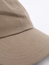 Gorra tipo trucker color beige con frente de algodón y parte trasera de malla transpirable.