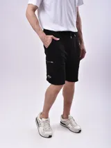 Bermuda negra de corte recto, con bolsillos laterales con cierre y logo estampado en la pierna izquierda.