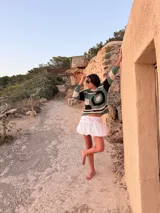 Sweater artesanal tejido a mano en crochet de 100% algodón, con diseño a rayas en tonos verde, negro, blanco y gris, de manga larga y corte recto.