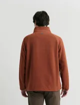 Sweater de micropolar color rojo, con cuello alto y cierre frontal parcial. Cuenta con mangas largas y bolsillos laterales con cierre.