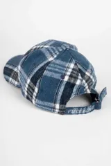 Gorro con visera tipo dad hat en color azul con patrón de cuadros estilo tartán en tonos blancos y negros.
