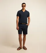 Bermuda masculina slim confeccionada en sarga de algodón con elastano, color beige, con bolsillos laterales tipo chino, bolsillos traseros embutidos con botón, trabillas en la cintura y cierre frontal con botón y cremallera.