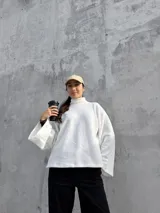 Polerón de cuello alto en color blanco, con diseño de calce holgado y mangas amplias. Confeccionado en tela suave y abrigada, ideal para un estilo urbano y relajado.