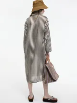 Vestido midi de seda con estampado de rayas verticales en tonos marrón y blanco. Presenta cuello camisero con cierre de botones frontal, mangas largas y aberturas laterales en el ruedo.