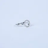 Anillo de plata 925 con diseño circular central adornado con pequeñas circonias brillantes.