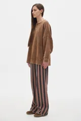 Buzo de algodón color crema, con cuello redondo y mangas largas, de calce oversize y hombros caídos. Presenta un pequeño bordado en el pecho.