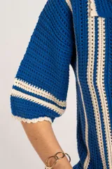 Cardigan oversize de crochet de algodón peinado, color azul con rayas verticales blancas, cuello tipo polo y cierre frontal de botones.