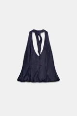 Top de mezclilla (denim) azul oscuro con cuello halter que se anuda en la espalda, escote pronunciado en pico y bajo abullonado con elástico. Presenta pespuntes contrastantes en color rojo.