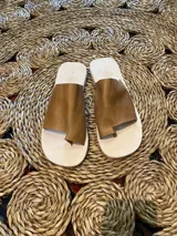 Sandalias de cuero color marrón claro, con base blanca y tira ancha sobre el empeine.