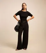 Blusa negra de viscosa con cuello redondo, mangas cortas y textura acanalada. Presenta un recorte oval en la espalda.