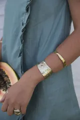 Brazalete rígido de diseño artesanal con textura irregular y acabado metálico, elaborado en bronce macizo.