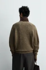 Cárdigan de punto con lana, color marrón, de corte relajado, cuello en pico, manga larga y cierre frontal con botones. Presenta puños y bajo en acabado rib.