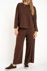 Sweater de manga larga color café, con textura gofrada y cuello redondo. Presenta una fina línea decorativa de color beige en el exterior de ambas mangas.