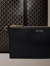 Cartera tote pequeña de Calvin Klein con estampado de monograma CK en color negro, asas de hombro dobles e incluye una cartera mini lisa a juego en el interior.