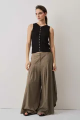 Blusa musculosa de punto color negro, con textura acanalada y silueta ajustada al cuerpo, decorada con una línea de ojalillos metálicos frontales.
