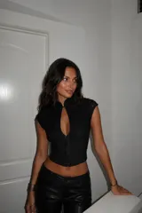 Top de encaje negro con cuello mao, cierre frontal tipo corset y mangas cortas. Presenta un diseño ajustado al cuerpo con una abertura frontal en el escote.