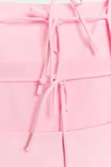 Vestido mini color rosado, con escote cuadrado, mangas cortas abullonadas y espalda descubierta con tiras finas cruzadas para atar.