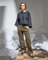 Pantalón verde militar tornasolado de algodón brillante, corte a la cintura y piernas rectas con textura de tableado central.