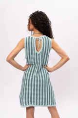 Vestido tejido a rayas verticales en tonos celeste y gris, sin mangas, con cuello redondo y corte recto. Incluye cinturón tejido con flecos.