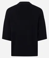 Blusa de manga corta amplia y sisas desplazadas, confeccionada en punto leve de viscosa y poliamida, con cuello redondo ligeramente alto.