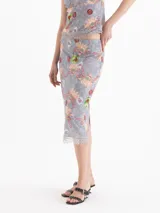 Pollera midi gris con estampado floral y detalles artísticos, de corte tubo y tiro medio, con terminación de encaje en el ruedo.