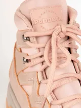 Bota de trekking color rosado con cordones al tono, cuello acolchado, ganchos metálicos para los cordones y suela dentada con plataforma gris y caramelo.