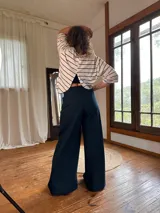 Blusa blanca con rayas horizontales negras, de corte clásico y mangas tres cuartos con cuello bote.