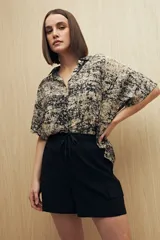 Short negro estilo cargo con cintura elastizada y cordón ajustable. Presenta bolsillos laterales con tapa y calce relajado.