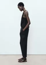Pantalón largo negro de lino con diseño recto, cintura elástica con cordón ajustable y bolsillos laterales.