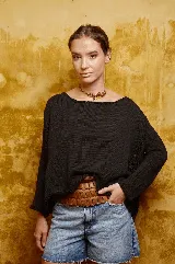 Sweater negro de algodón tejido a mano con apliques de crochet en los laterales y cuello bote amplio.