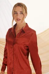 Camisa beige con estampado de líneas diagonales, cuello clásico, cierre con botones y mangas largas con puños abotonados.