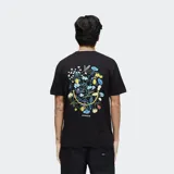 Remera negra con estampado de flores formando una cara sonriente en la espalda y logo de la marca Stance en la parte inferior.
