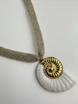 Collar dorado tejido con dije de caracol blanco y dorado.