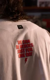 Remera blanca de manga corta y cuello redondo con calce oversize. Presenta un estampado frontal artístico y colorido de David Bowie.