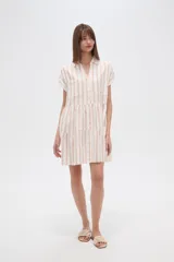 Vestido corto de corte holgado con diseño de rayas verticales en tonos claros. Presenta cuello camisero, cierre frontal con botones, mangas cortas y falda con volados escalonados.