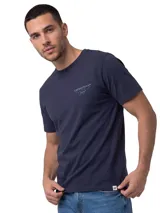 Remera Caterpillar de color azul marino, de manga corta y cuello redondo. Cuenta con un pequeño gráfico bordado en el pecho y un parche de la marca en el borde inferior.