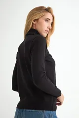 Polera de cuello alto y manga larga, confeccionada en tejido de punto fino, con ajuste al cuerpo y puños acanalados.