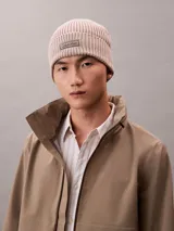 Gorro tipo beanie de punto acanalado en color beige, con vuelta y parche frontal con el logo de Calvin Klein.