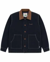 Campera estilo workwear de color azul oscuro, confeccionada en canvas resistente con interior de corderito sherpa. Presenta cuello de pana en color marrón, cierre frontal con botones metálicos color cobre, dos bolsillos frontales amplios y bordado de la marca en el pecho.