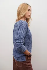 Buzo de tejido de punto en color azul con diseño geométrico texturizado, cuello redondo y mangas largas.